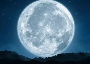 primo piano di una luna piena brillante in un cielo stellato