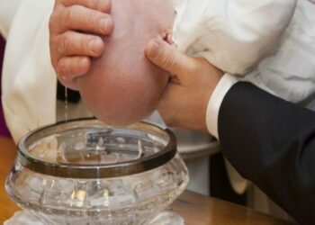 neonato ride e batte le mani -min
