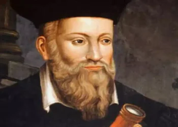 Ritratto storico di Nostradamus con lunga barba e abiti rinascimentali mentre osserva uno strumento ottico, immagine associata alle celebri profezie e alle interpretazioni sulle previsioni per il futuro e il 2027