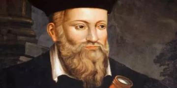 Ritratto storico di Nostradamus con lunga barba e abiti rinascimentali mentre osserva uno strumento ottico, immagine associata alle celebri profezie e alle interpretazioni sulle previsioni per il futuro e il 2027