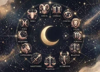Ruota dello zodiaco astrologica con i segni zodiacali dorati e una luna crescente al centro su sfondo di cielo notturno blu stellato. Oroscopo
