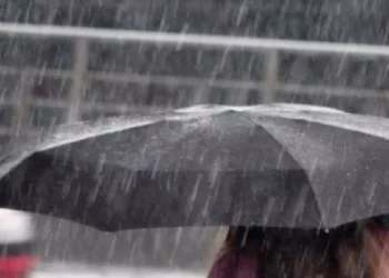 Ombrello nero sotto una pioggia intensa durante un forte temporale, immagine che rappresenta il maltempo al Sud Italia con rischio di nubifragi, vento forte e possibili fenomeni associati a un ciclone mediterraneo o medicane.