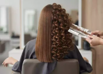 Donna con capelli ricci perfetti e definiti al risveglio grazie al trucco della carta stagnola, metodo senza ferro per ottenere boccoli naturali e ridurre l'effetto crespo.