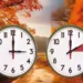Due orologi da parete analogici su uno sfondo di paesaggio autunnale