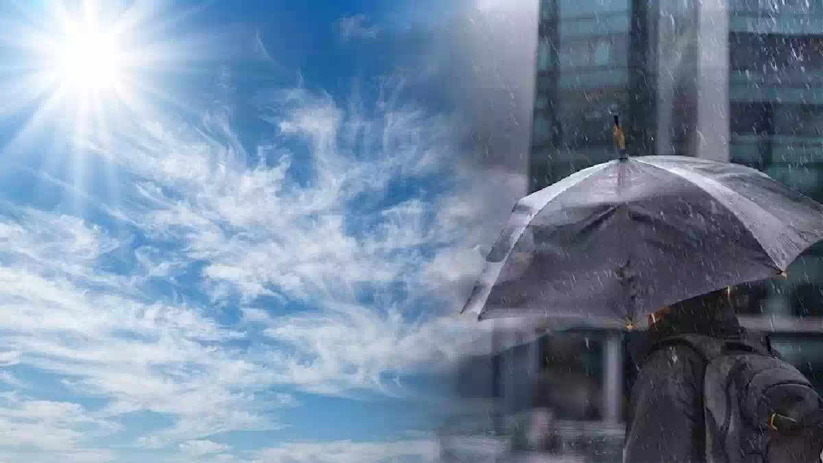 Contrasto meteorologico di fine settembre con sole splendente e cielo sereno da un lato, pioggia intensa e ombrello sotto un temporale urbano