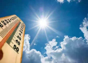 Termometro con temperature elevate sotto un sole splendente nel cielo azzurro, previsione di caldo anomalo e clima quasi estivo sull'Italia tra fine settembre e inizio ottobre