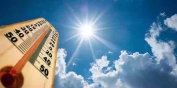 Termometro con temperature elevate sotto un sole splendente nel cielo azzurro, previsione di caldo anomalo e clima quasi estivo sull'Italia tra fine settembre e inizio ottobre