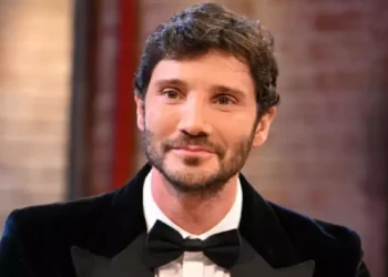Stefano De Martino in primo piano con smoking nero e papillon durante un'apparizione televisiva, immagine associata alle novità del regolamento del Festival di Sanremo 2027 e alla nuova era della manifestazione canora italiana.