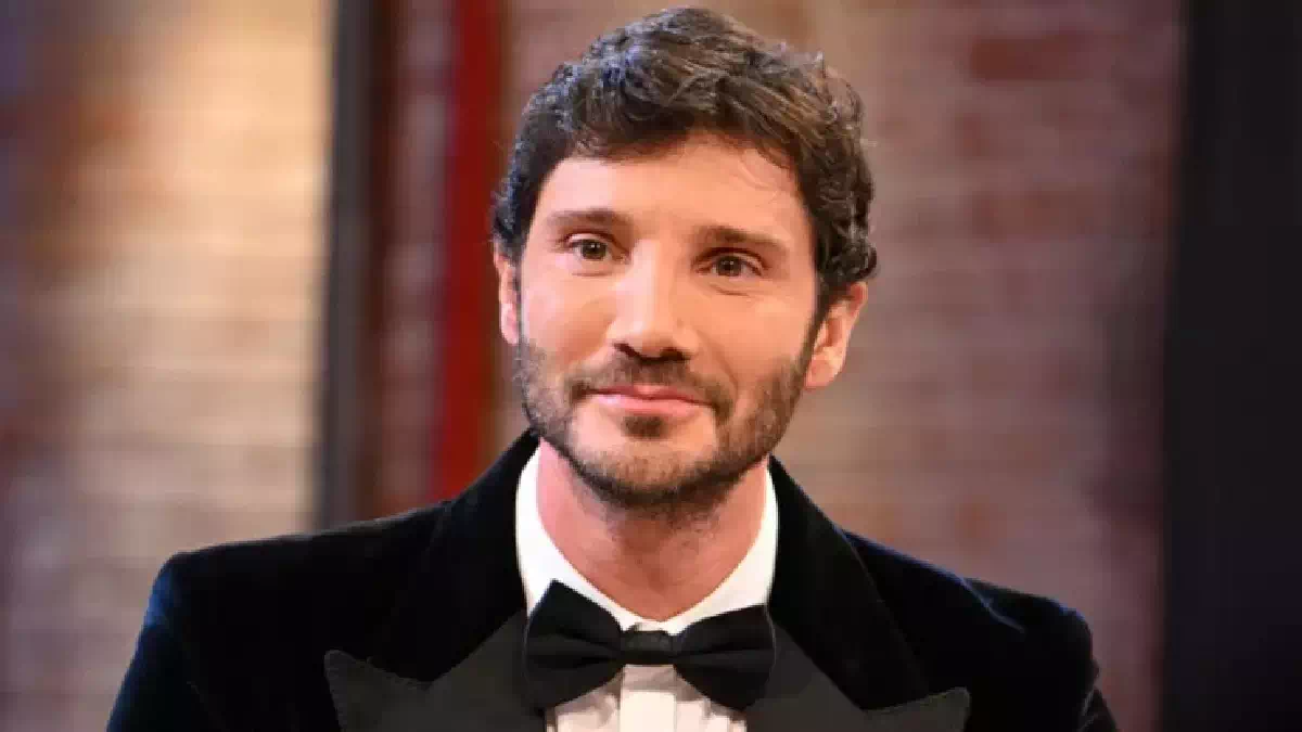 Stefano De Martino in primo piano con smoking nero e papillon durante un'apparizione televisiva, immagine associata alle novità del regolamento del Festival di Sanremo 2027 e alla nuova era della manifestazione canora italiana.