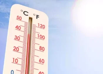 Termometro con temperatura elevata sotto un sole intenso nel cielo sereno, simbolo dell'aumento delle temperature globali e degli effetti di El Niño sul clima mondiale