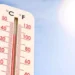 Termometro con temperatura elevata sotto un sole intenso nel cielo sereno, simbolo dell'aumento delle temperature globali e degli effetti di El Niño sul clima mondiale