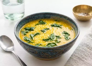 Fregola con crema di ceci e cavolo nero servita in una ciotola rustica, primo piatto invernale ricco di fibre e proteine vegetali, ideale per una dieta sana e nutriente