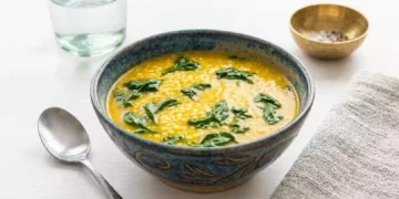 Fregola con crema di ceci e cavolo nero servita in una ciotola rustica, primo piatto invernale ricco di fibre e proteine vegetali, ideale per una dieta sana e nutriente