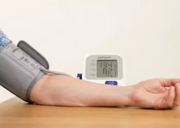 Misurazione della pressione arteriosa a domicilio con misuratore elettronico da braccio appoggiato su un tavolo