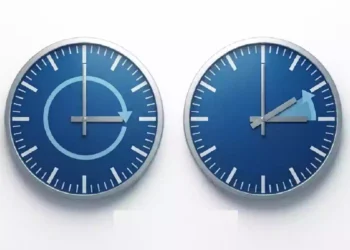 Cambio dall’ora legale all’ora solare 2026 con due orologi blu che mostrano lo spostamento delle lancette indietro di un’ora nella notte del 25 ottobre