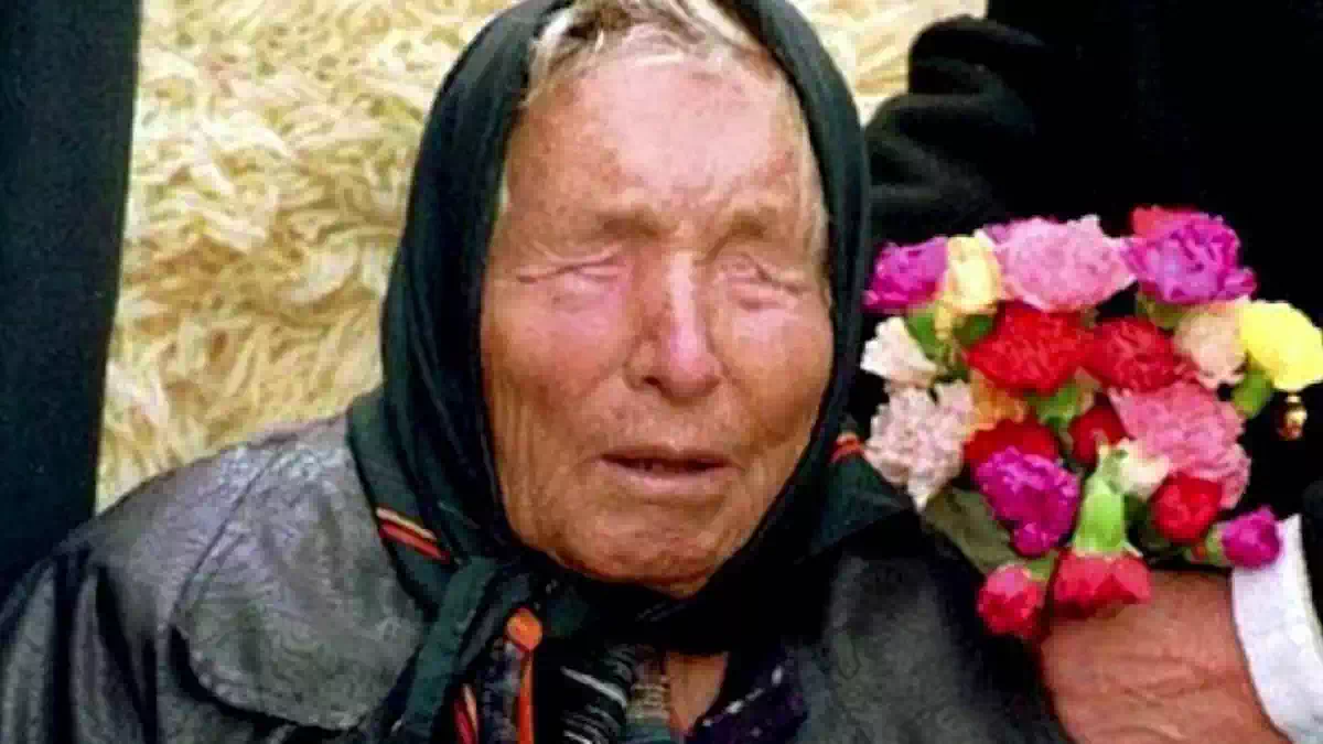 Baba Vanga durante un'apparizione pubblica, ritratta con un foulard nero sul capo e un mazzo di fiori colorati accanto, simbolo delle celebri profezie