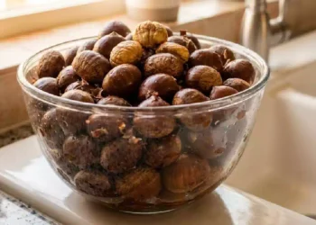 Castagne immerse in una bacinella d’acqua durante il controllo preliminare prima della cottura, metodo tradizionale utilizzato per verificare lo stato dei frutti