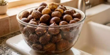 Castagne immerse in una bacinella d’acqua durante il controllo preliminare prima della cottura, metodo tradizionale utilizzato per verificare lo stato dei frutti