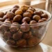 Castagne immerse in una bacinella d’acqua durante il controllo preliminare prima della cottura, metodo tradizionale utilizzato per verificare lo stato dei frutti