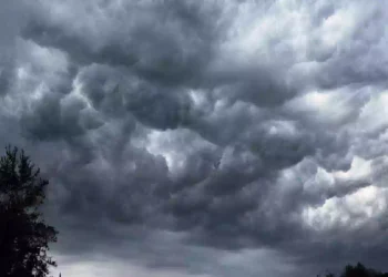Una vista dal basso di intense formazioni nuvolose mammatus scure e turbolente che riempiono la maggior parte del cielo