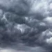 Una vista dal basso di intense formazioni nuvolose mammatus scure e turbolente che riempiono la maggior parte del cielo